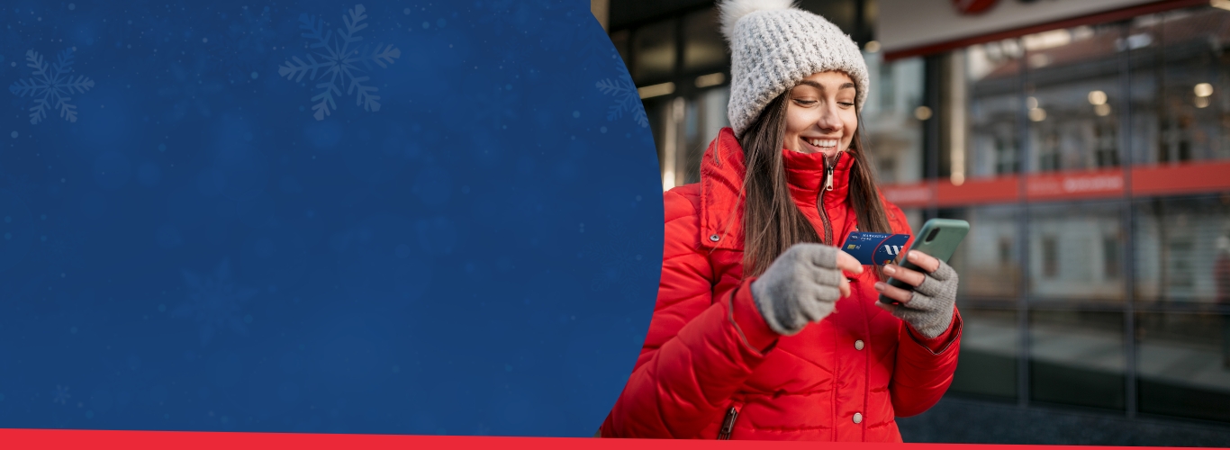 Women in winter clothes looking at her Manasquan Bank Mastercard card